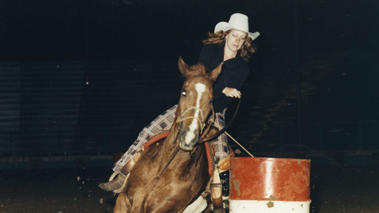 Reba rides horse around barrel 